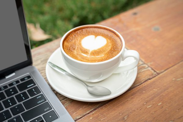 coffee cup next to laptop