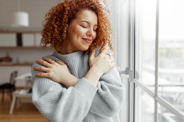 Woman hugging self