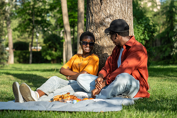 Couple sitting in dappled sunshine in the park